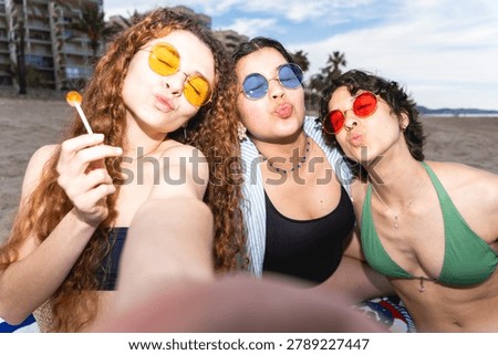 Three friends making kissy faces and having fun on a sunny beach day