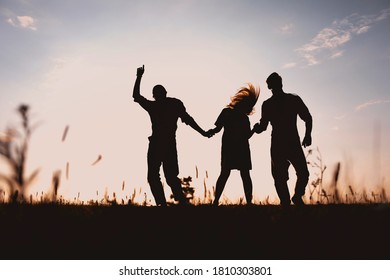 Three Friends Running Across The Field At Night