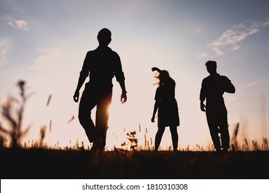 Three Friends Running Across The Field At Night