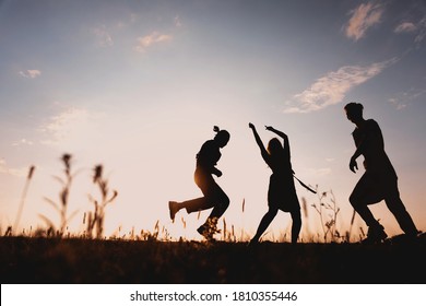 Three Friends Running Across The Field At Night