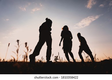 Three Friends Running Across The Field At Night