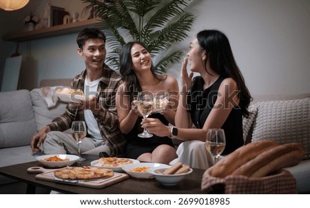 Three friends sharing snacks, drinks, and laughter during a fun evening at home.