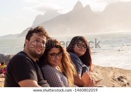 Three friends sitting and watching the sunset at Pedra do Arpoador, Arpoador Beach, Rio de Janeiro, Brazil