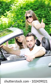 Three Friends In A Sports Car With Thumbs Up