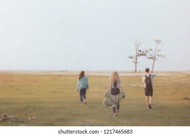 Three friends walking down by the Baikal lake coast.