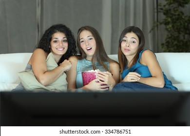 Three Friends Watching Romantic Movie On Tv Sitting On A Couch At Home