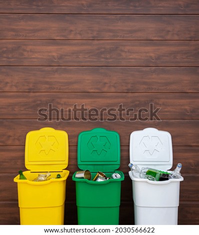Three full dustbins for sorting trash on the backyard