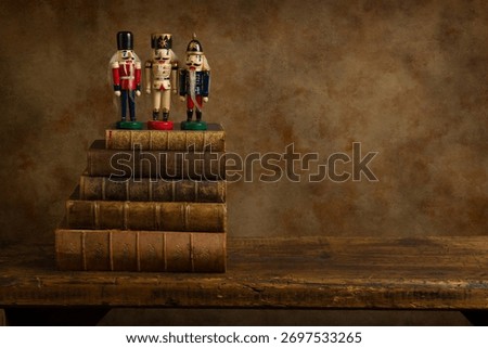 Three funny nutcracker puppets on old books on a rustic old wooden shelf. This is suitable for digital compositing.