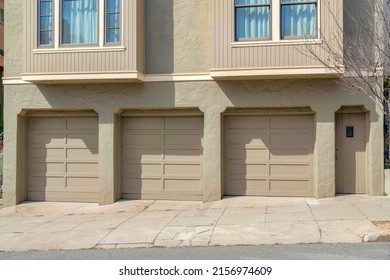 Three garage doors of a house with light gray exterior at San Francisco, California
