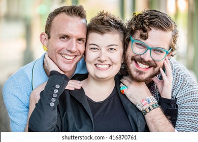 Three gender fluid friends pose and smile