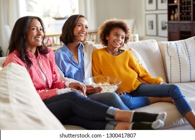 Three generation African American family female family group spending time together sitting on the sofa watching TV at home, selective focus - Powered by Shutterstock