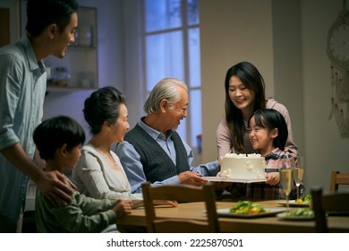 three generation asian family gathering at home celebrating senior couple's wedding anniversary - Powered by Shutterstock