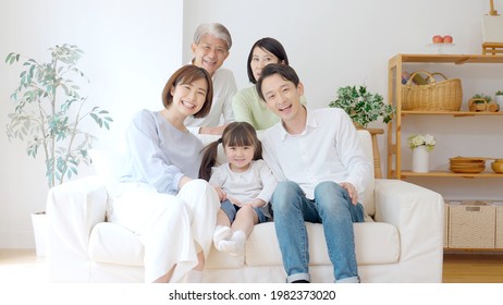 three generation asian family relaxing in the living room