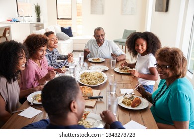 Three Generation Black Family Sitting At The Table Talking And Eating Dinner Together, Close Up