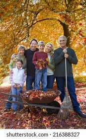 Three Generation Family Doing Yard Work In Autumn