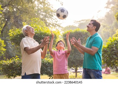 Three generation family having fun while playing with ball at park. - Powered by Shutterstock