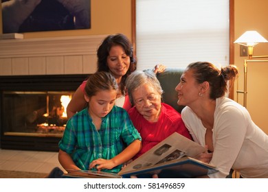 Three Generation Family Looking At Photo Album