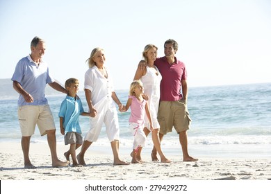 Three Generation Family On Holiday Walking On Beach