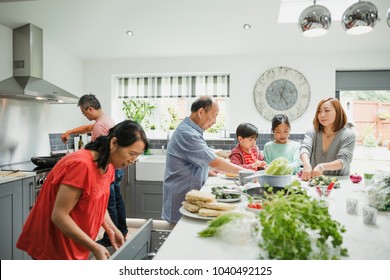 Three generation family are preparing vegetables for a stir fry in the kitchen of their home together.  - Powered by Shutterstock