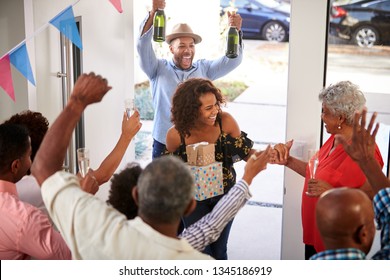 Three Generation Family Throwing A Surprise Party Welcoming Guests At The Front Door,elevated View