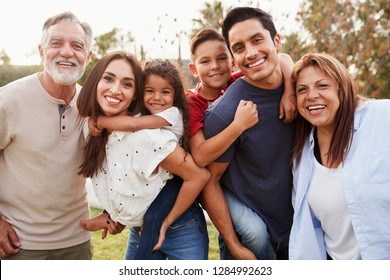 Three generation Hispanic family standing in the park, smiling to camera, selective focus - Shutterstock ID 1284992623