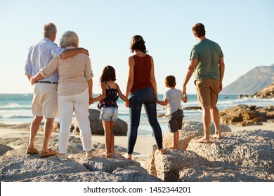 Three Generation White Family On A Beach Stand Holding Hands, Admiring View, Full Length, Back View