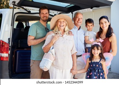 Three Generation White Family Standing By Car Smiling To Camera Before Leaving For Vacation