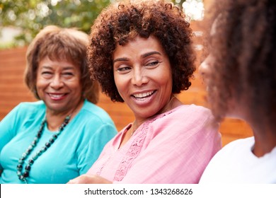 Three Generations Of Female Family Members Talking Outside