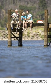 Three Generations Fishing On Jetty, Boy (10-12) Flanked By Father And Grandfather