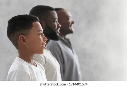 Three Generations Men Family Portrait. Side View Shot Of Black Male In 3 Different Ages, Boy, His Father And Grandfather Posing Indoors, Free Space