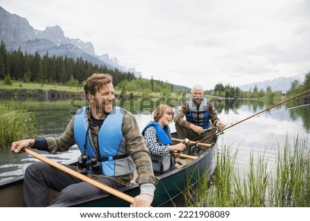 Three generations of men fishing in lake