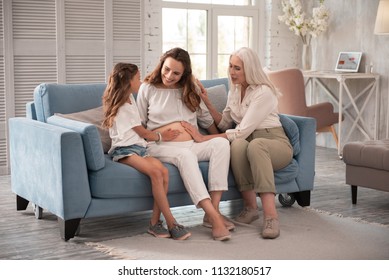 Three generations. Pregnant woman feeling simply amazing sitting between her mother and daughter