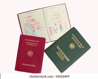 Three German Passports, Two In Red And One Old Passport In Green. There Are Different Stamp Of Entry In Different Countries.