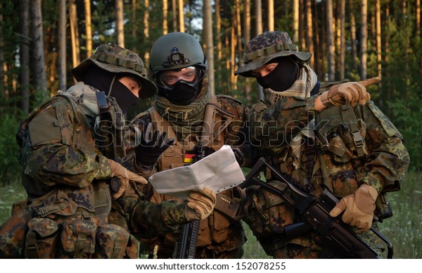 Three german soldiers discuss a plan of action.\
Coordinate the team.