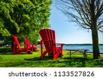 Three giant red adirondack chairs at Brockville overlooking the Thousand Islands, and St. Lawrence River