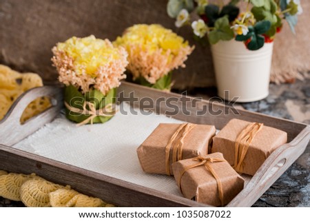 Three gift boxes in a kraft wrapper on a gray concrete background on a wooden table. place for your inscription