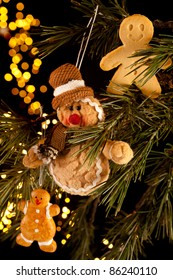 Three Gingerbread Men Hanging In A Christmas Tree, Two Fake And One Real Cookie