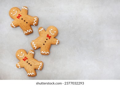 Three gingerbread men on mottled grey surface - Powered by Shutterstock