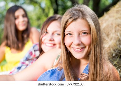Three girl friends having fun on hay stack
