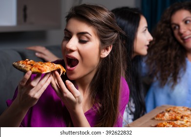 Three Girlfriends Eating Pizza At Home