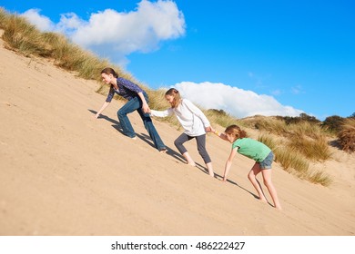 Three Girls Climbing Up Sand Dune