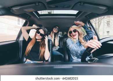 Three Girls Driving In A Convertible Car And Having Fun