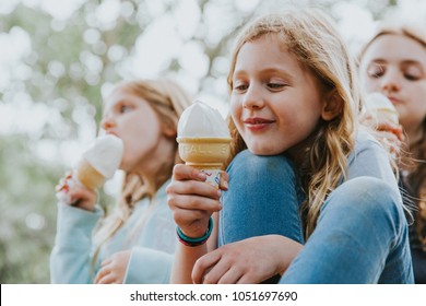 Three Girls Eating Vanilla Ice Cream On A Hot Summer Day