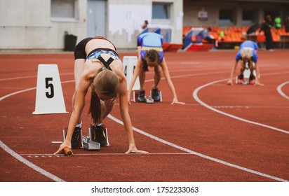 three girls on starting blocks start the relay - Powered by Shutterstock