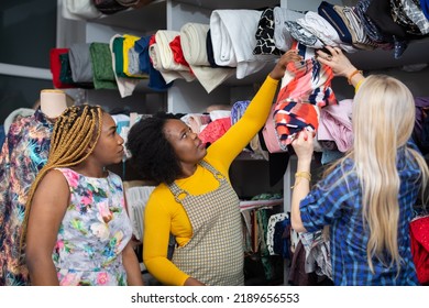 Three Girls Take A Selected Fabric Off The Rack. Tailoring.