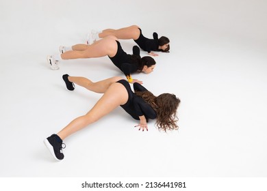 Three Girls Twerking On White Background In Studio. Women Show Sexy Dancing