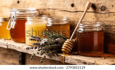 Three Glass Jars with Different Types of Honey on Vintage Wooden Shelf, Rustic Still Life with Honey Dipper, Fresh Rosemary, Thyme and Lavender, Organic Raw Honey and Healthy Natural Food Concept.