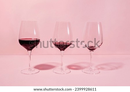 Three glasses with different level of red wine poured, quit drinking, cutting back on alcohol concept