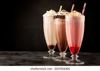 Three glasses of milkshake with assorted flavors. Chocolate, vanilla and strawberry milkshake. - Shutterstock ID 2019356306