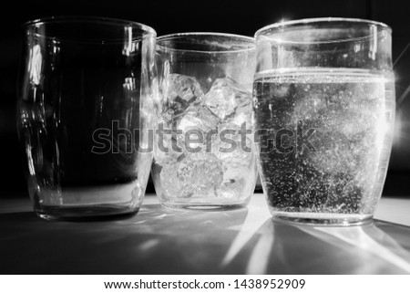 Three glasses representing three states of matter. Liquid, gas and solid.